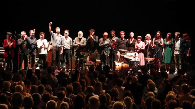 Multiple musicians, male & female, on the NCH stage taking a bow