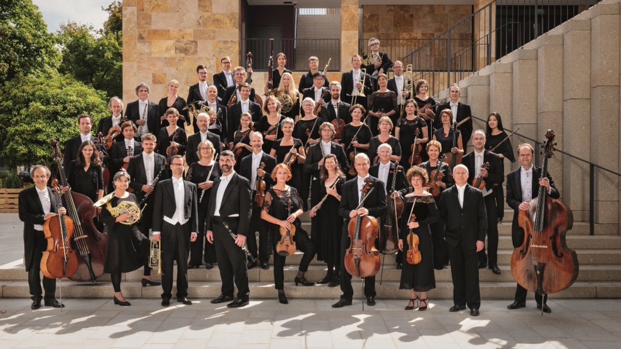 The Deutsche Kammerphilharmonie Bremen - orchestra members dressed in black on steps holding musical instruments