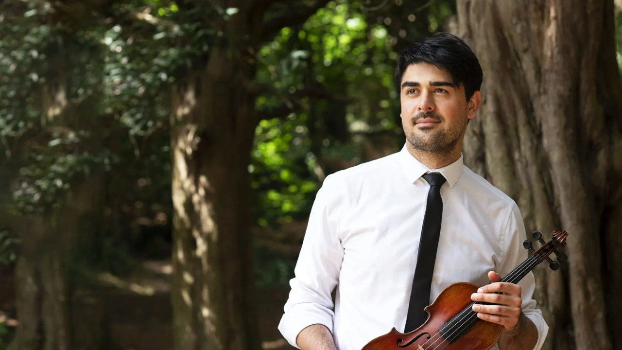 David Tobin - man in white shirt and black tie holding violin against a park backdrop