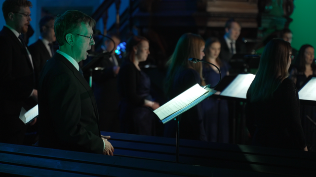Singers from Chamber Choir Ireland singing in a darkly lit venue