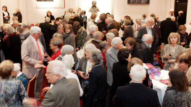 Men and women mingling at an event in the John Field Room at NCH