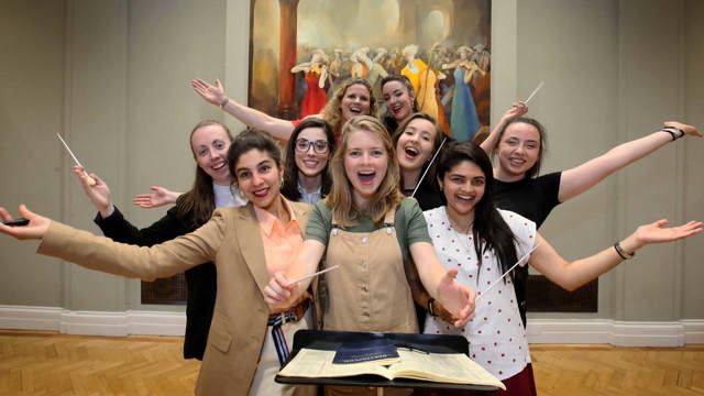 Participants in the Female Conductor Programme posing with their arms outstretched looking directly at the camera